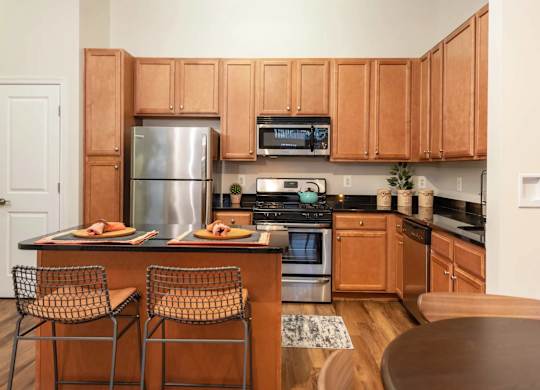 A kitchen with wooden cabinets and a stainless steel refrigerator.