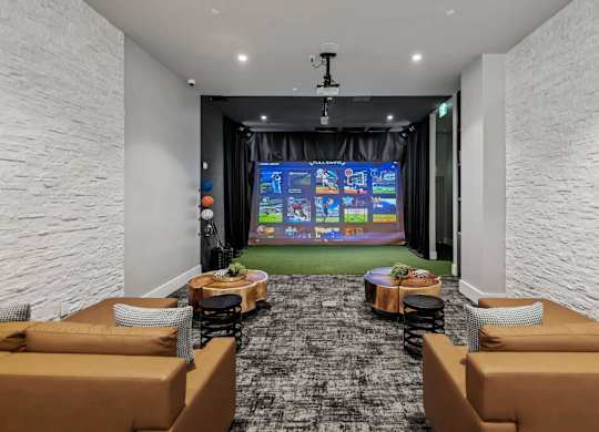 A room with a large screen and comfortable seating.