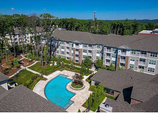 A large apartment complex with a swimming pool in the foreground.