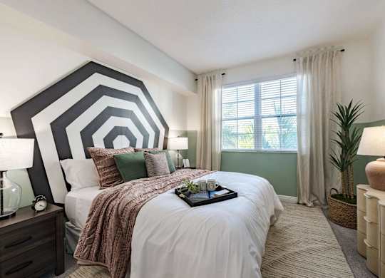 A bedroom with a large bed and a tray of flowers on it.