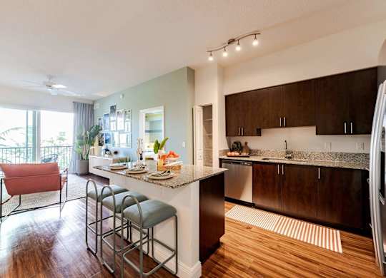 A modern kitchen with a bar stool and a dining table.