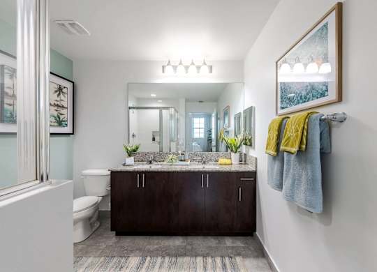 A bathroom with a white toilet and a brown vanity.