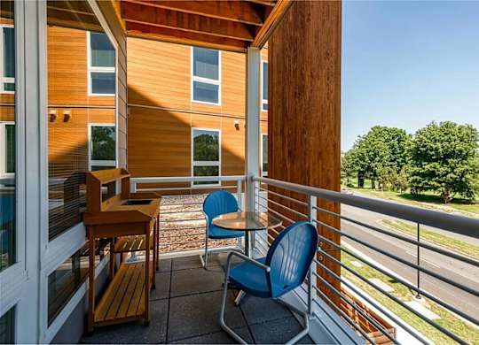 A balcony with a blue chair and a table.