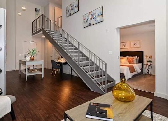 A living room with a staircase and a book on the coffee table.