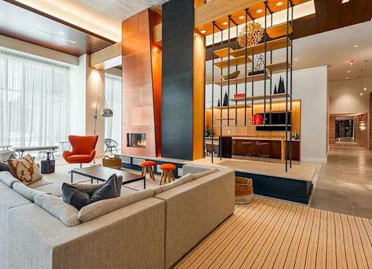 A modern living room with a large sectional sofa and a fireplace.