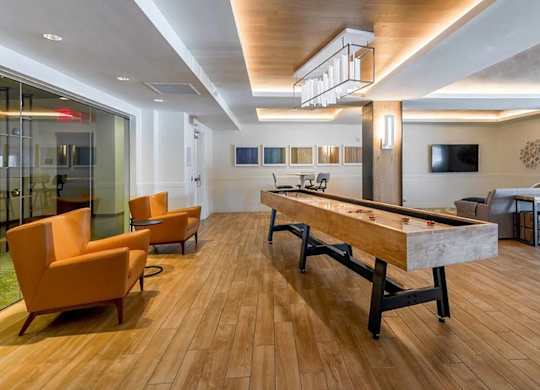 A room with a pool table and chairs.