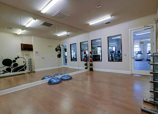 A room with wooden floors and mirrors on the wall.