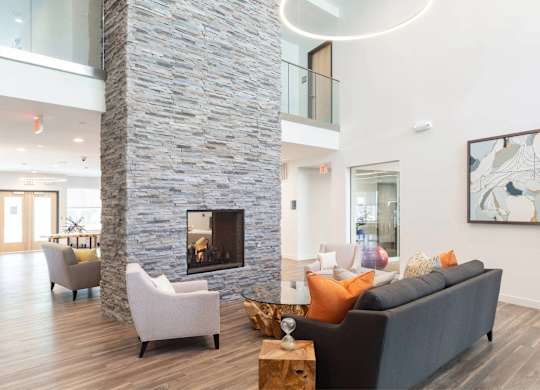 A modern living room with a stone pillar and a fireplace.