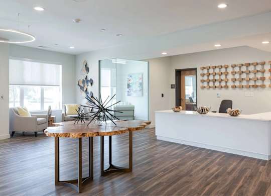 A reception area with a white counter and a wooden table with a metal star decoration.