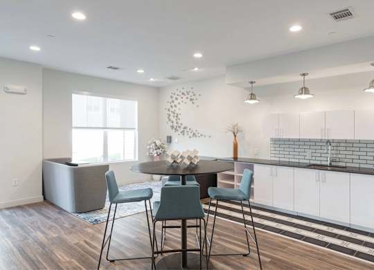 A modern kitchen with a dining table and chairs.