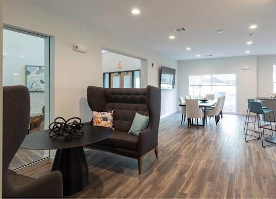 A living room with a brown couch and a black coffee table.