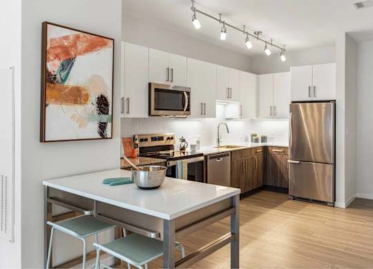 A modern kitchen with a table and chairs in the foreground.