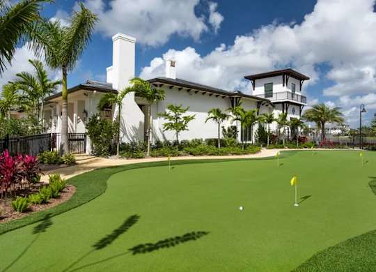 A golf course with a house in the background.