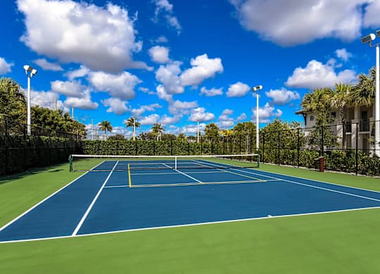A tennis court with a blue surface and white lines.