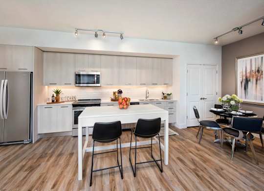A modern kitchen with a white table and chairs.