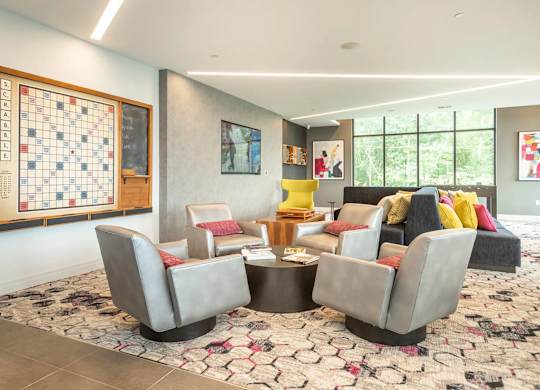 A living room with a Scrabble board on the wall.