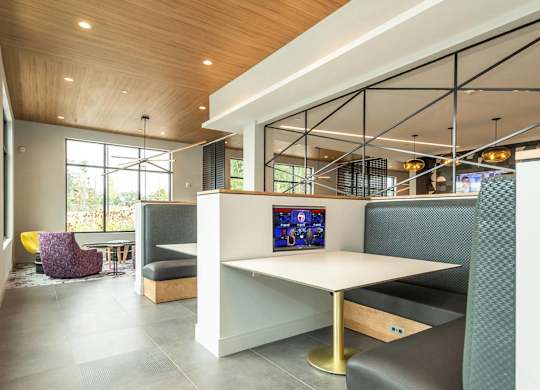 A modern lounge area with a white table and purple chairs.