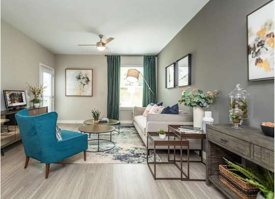 A living room with a blue chair and a white couch.