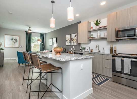 A modern kitchen with a large island and bar stools.