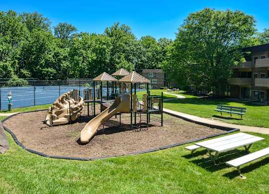 A playground with a slide, swings, and a canopy.