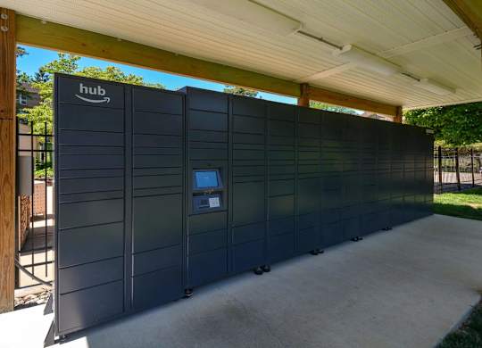 A row of Amazon lockers are lined up under a roof.