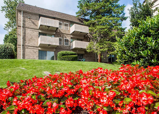 A building with a balcony and a green lawn in front.
