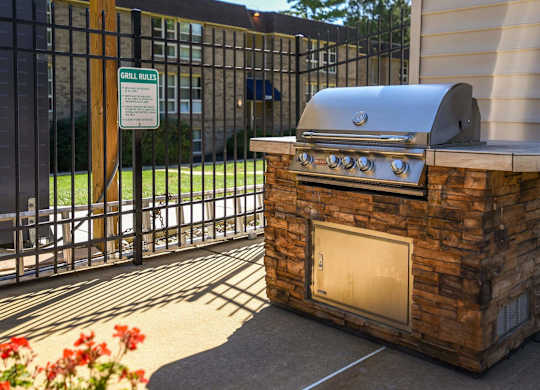 A BBQ grill is placed on a stone base.