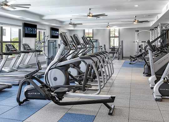 A gym with treadmills and elliptical machines.