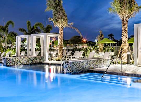 A pool with a blue tiled edge and a white structure in the background.