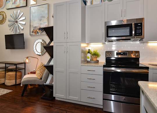 A modern kitchen with a stove, oven, and cabinets.