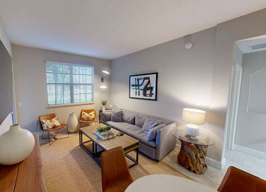 A living room with a grey couch, a white table, and a television.
