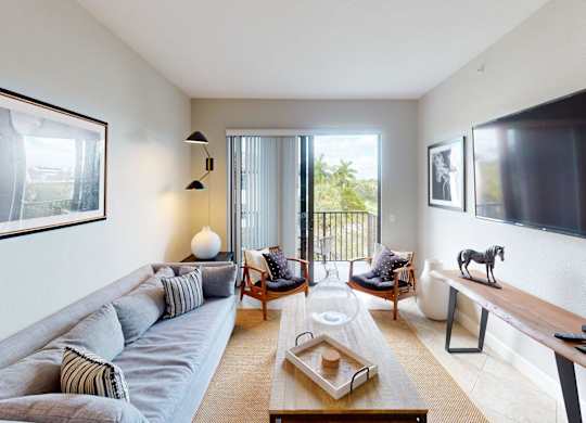 A living room with a grey couch and a wooden coffee table.