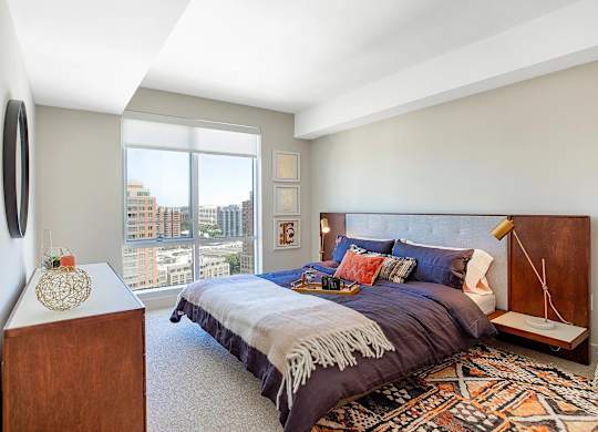 A bedroom with a large bed and a view of the city.