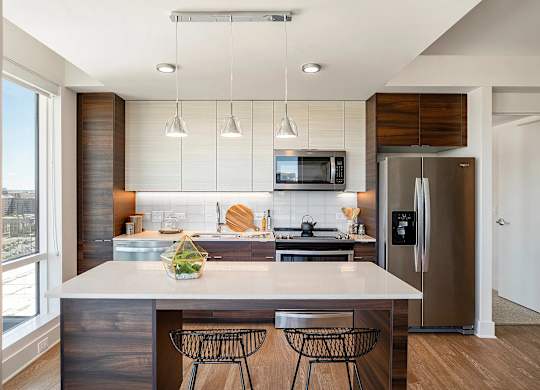 A modern kitchen with a large island and stainless steel appliances.