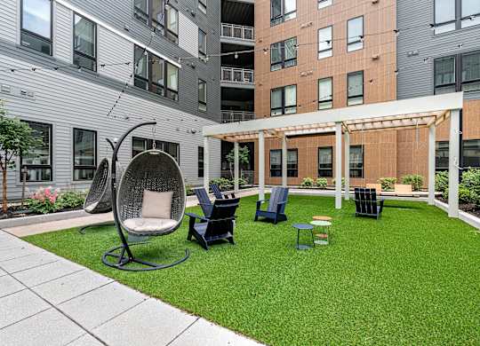 A patio with a white chair and a black table.