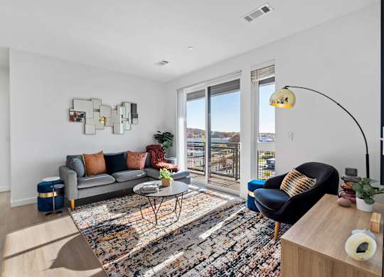 A living room with a grey couch and a black chair.