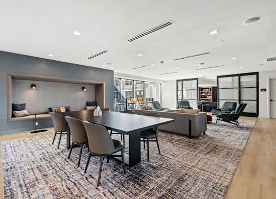 A modern dining room with a large table and chairs.