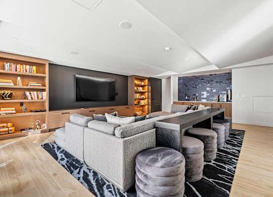 A modern living room with a grey sofa and a black television.
