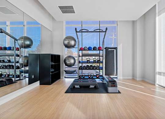 A gym with a variety of equipment including weights and a treadmill.
