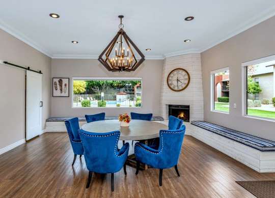 A dining room with a table set for six and a chandelier hanging from the ceiling at Red Mountain Apartments, Mesa, AZ