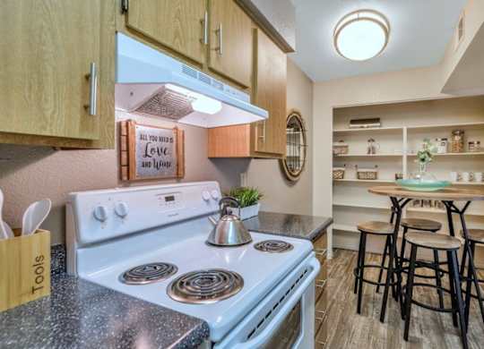 A kitchen with a stove and a sign that says at Red Mountain Apartments, Mesa, AZ