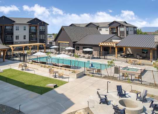 A large outdoor swimming pool surrounded by lounge chairs and umbrellas.