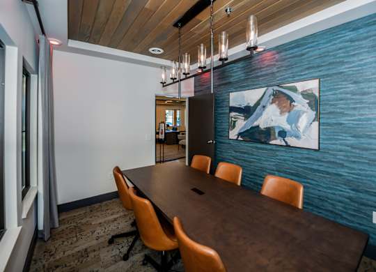 A conference room with a long table and chairs.