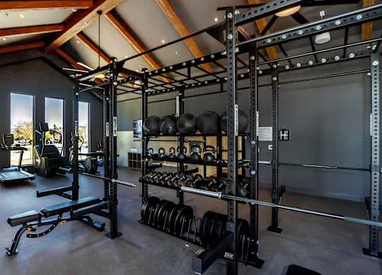 A gym with a variety of weightlifting equipment.