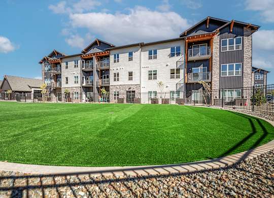 A large grassy area in front of a multi-story building.
