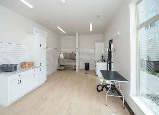 A kitchen with white cabinets and a black table.