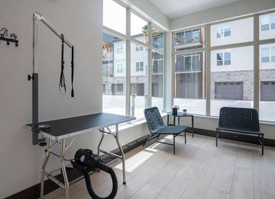 A room with a table, chairs and a vacuum cleaner.