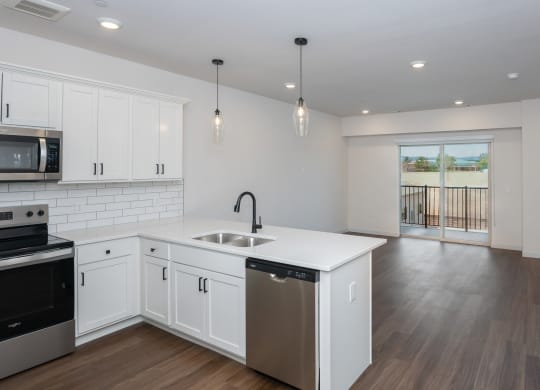 a renovated kitchen with white cabinets and a white counter top and a stainless steel sink at The Crossings  at Windsong, Prescott Valley, 86314