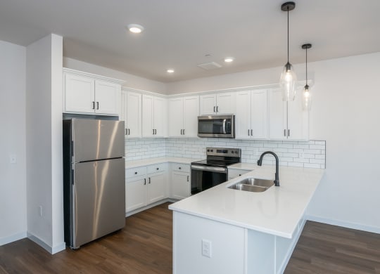 a renovated kitchen with white cabinets and stainless steel appliances at The Crossings  at Windsong, Prescott Valley, AZ