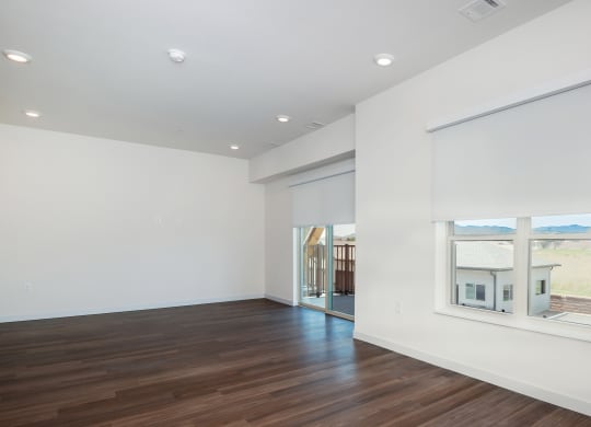 a living room with white walls and a large window at The Crossings  at Windsong, Prescott Valley, 86314